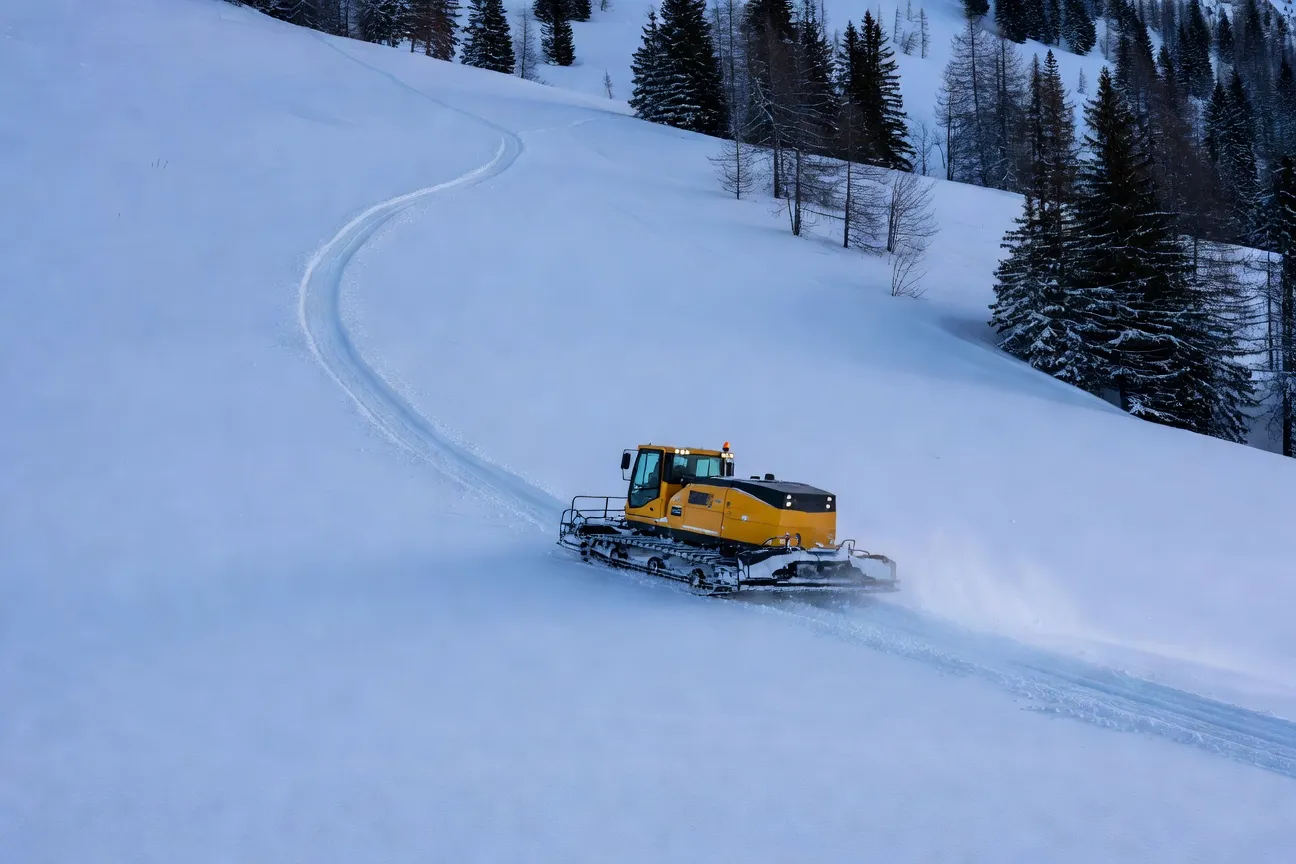 Damage matinal des pistes a Metabief avec dameuse et soleil levant
